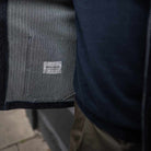 Close-up of a dark jacket with a brand label on a blurred background