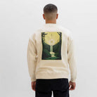 Person wearing a beige paradaiza sweat with a graphic design on the back against a white background