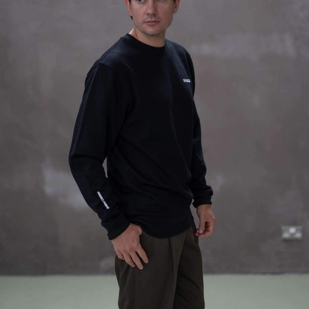 Person wearing a paraddaiza black long-sleeve sweatshirt 