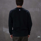 Person wearing a paraddaiza black long-sleeve sweatshirt 