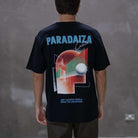 Person wearing a black t-shirt with 'Paradaiza' branding and colorful design on the back against a gray background