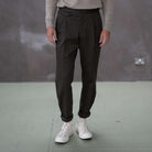 Person wearing paradaiza pinch chinos pants and white sneakers with red and blue designs on a plain background