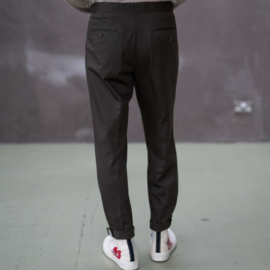 Person wearing paradaiza pinch chinos pants and white sneakers with red and blue designs on a plain background