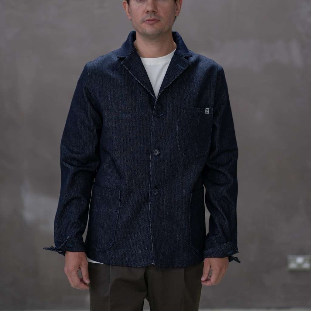 Man wearing a paradaiza dark denim jacket against a gray background