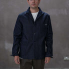 Man wearing a paradaiza dark denim jacket against a gray background