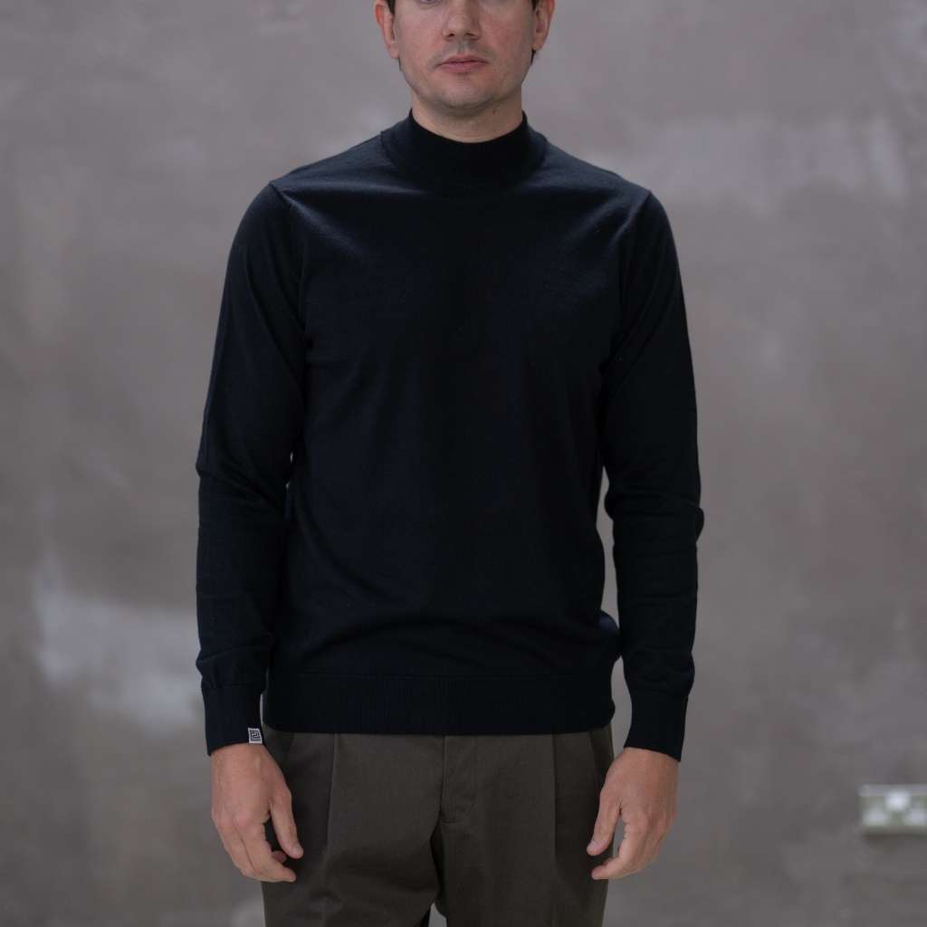 Model wearing a  paradaiza black turtleneck sweater against a gray background