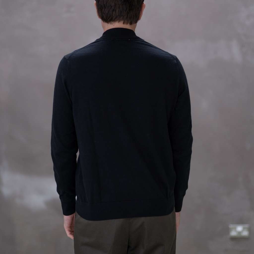 Model wearing a  paradaiza black turtleneck sweater against a gray background