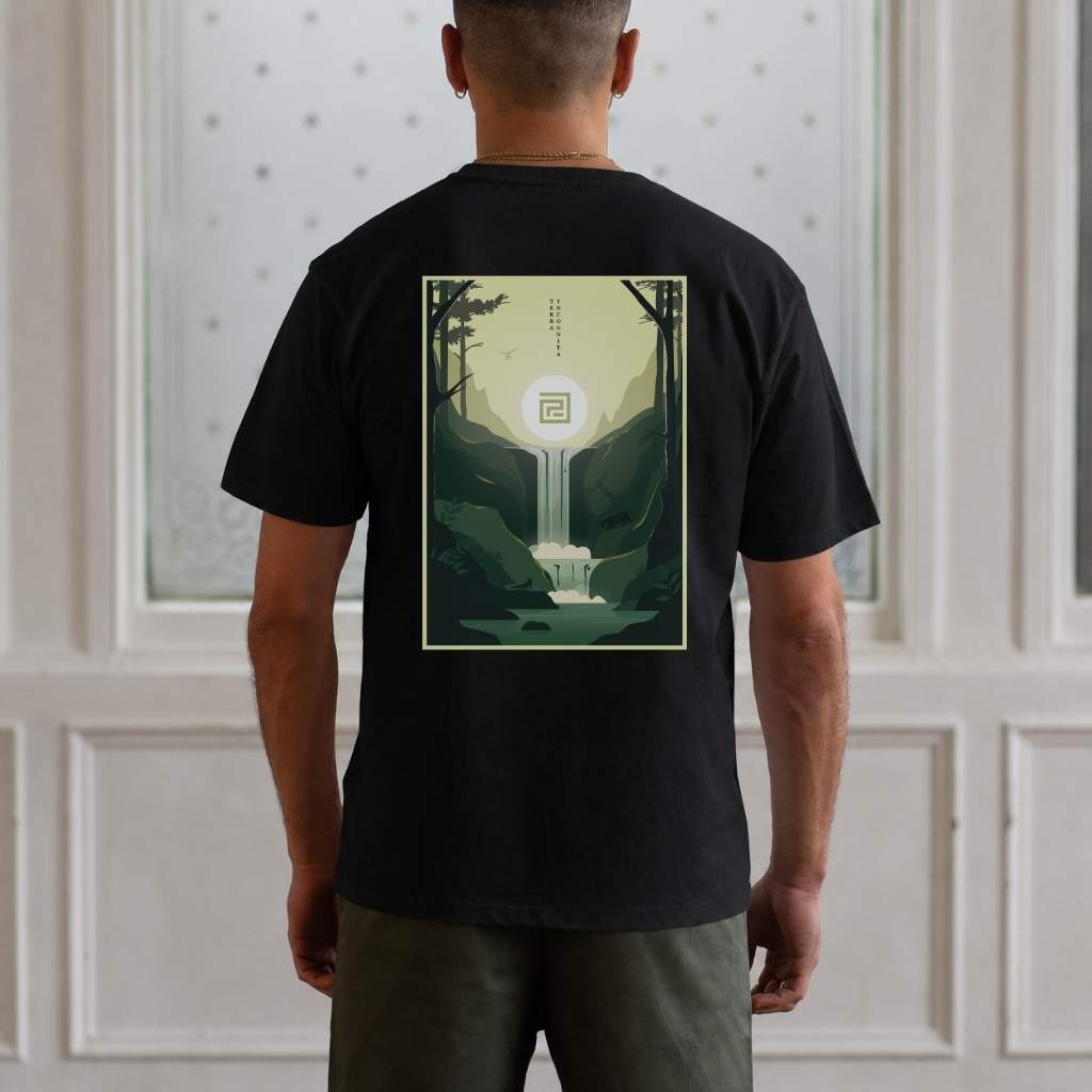 Person wearing a black t-shirt with a nature-themed design on the back, standing against a white paneled wall.
