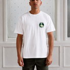 model wearing a white paradaiza tee with terra incognita bage on the chest